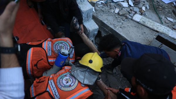 Palestinian medics work to rescue a man from the rubble of a building which collapsed following Israeli bombardment in Rafah in the southern Gaza Strip on December 1, 2023. (Said Khatib/ AFP)