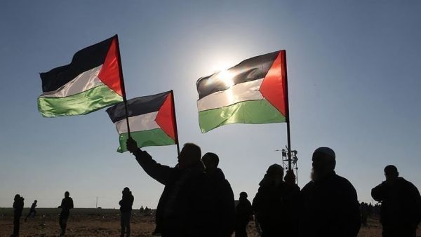 فلسطينيون يرفعون علم بلادهم