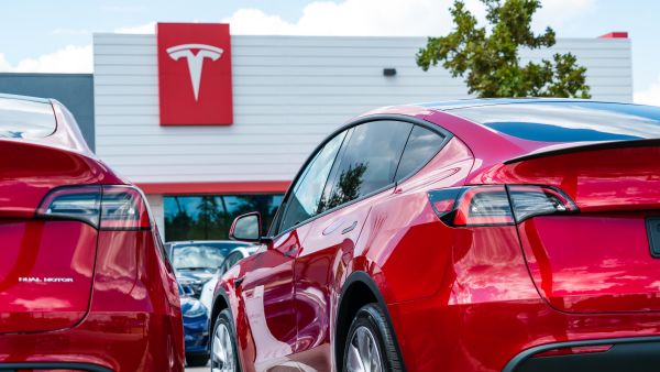 Two red model Y in front of Tesla Motors
