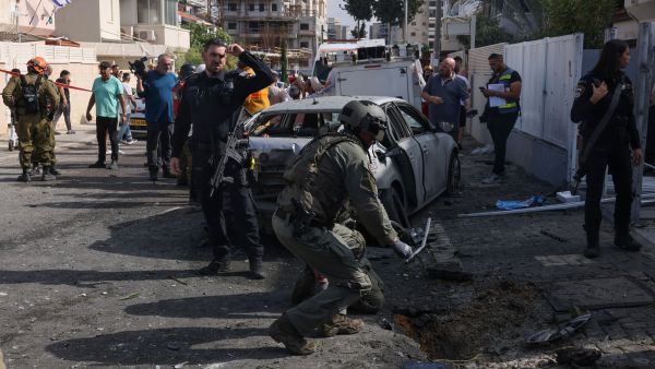 Israeli security and emergnecy personnel deploy at the site where a rocket launched from Gaza fell, in the southern city of Ashkelon on November 14, 2023, amid ongoing battles between Israel and the Palestinian Hamas movement.