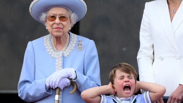 Britain's Prince Louis of Cambridge (R) holds his ears as he stands next to Britain's Queen Elizabeth II to watch a special flypast from Buckingham Palace balcony following the Queen's Birthday Parade, the Trooping the Colour, as part of Queen Elizabeth II's platinum jubilee celebrations, in London on June 2, 2022.  Queen Elizabeth II