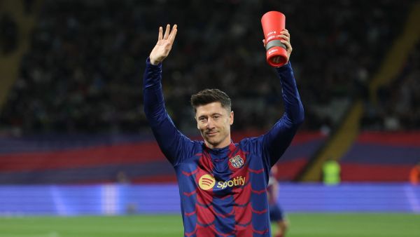 Barcelona's Polish forward #09 Robert Lewandowski waves as he holds La Liga Best Player of the Month trophy before the Spanish league football match between FC Barcelona and RCD Mallorca at the Estadi Olimpic Lluis Companys in Barcelona on March 8, 2024. (Photo by LLUIS GENE / AFP)