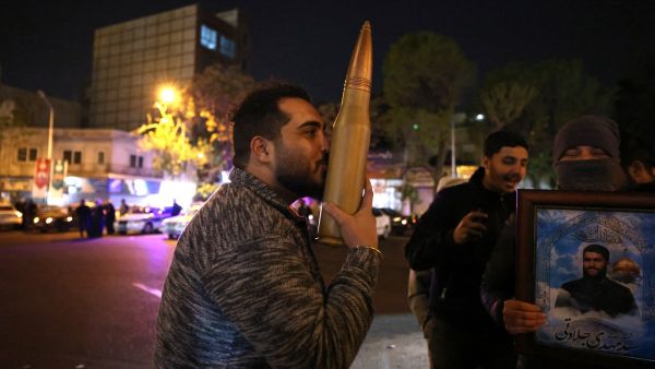 A demonstrator kisses a bullet shell replica as others gather at Palestine Square in Tehran on April 14, 2024, after Iran launched a drone and missile attack on Israel. Iran's Revolutionary Guards confirmed early April 14, 2024 that a drone and missile attack was under way against Israel in retaliation for a deadly April 1 drone strike on its Damascus consulate. (Photo by ATTA KENARE / AFP) Iran ends Its response with a threatening message to Israel and America