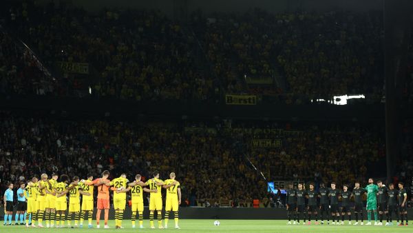 Dortmund's's players (L) and Paris Saint-Germain's players line up as the stadium observes a minute of silence for victims of recents flooding in Libya and an earthquake in Morocco prior to the UEFA Champions League 1st round Group F football match between Paris Saint-Germain (PSG) and Borussia Dortmund (BVB) at the Parc des Princes stadium in Paris on September 19, 2023. (Photo by FRANCK FIFE / AFP)