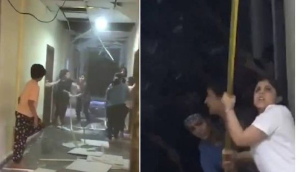 فتيات يستخدمن عصيا طويلة لتكسير الأبواب وسقف المبنى