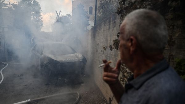 TOPSHOT - People check a burnt car in the small town of Zababdeh, southeast of Jenin in the occupied West Bank on August 30, 2024, following an Israeli army raid. The Israeli military said it killed three Palestinian fighters in an air strike on the third day of its raids in the occupied West Bank, claiming they belonged to the Islamist Hamas movement, which has been at war with Israel in Gaza. (Photo by RONALDO SCHEMIDT / AFP) Israeli forces assassinate Hamas commander in Jenin