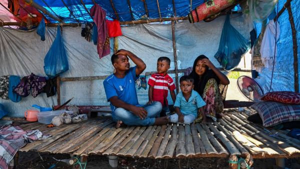 A family rests in their shelter for Rohingya refugees at Kulee beach, in Pidie district, Indonesia's Aceh province. (Photo by CHAIDEER MAHYUDDIN / AFP) Rohingya