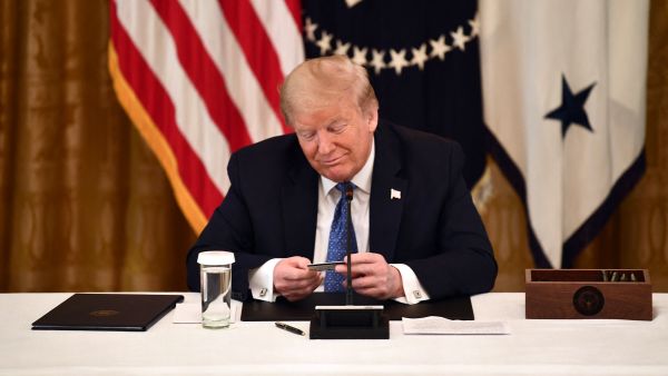 US President Donald Trump looks at a pre-paid debit card during a meeting with his cabinet on May 19, 2020 in the Cabinet Room of the White House in Washington, DC. (AFP / Brendan Smialowski) As Trump gets back in office, how much is the US president salary?
