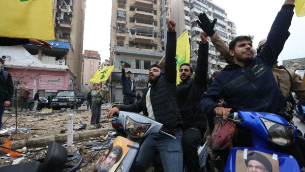 لبنانيون يرفعون رايات حزب الله بين ركام المباني المدمرة في الضاحية الجنوبية 