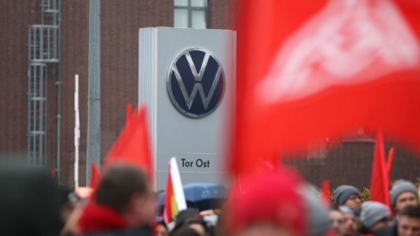 The logo of German automobile manufacturer Volkswagen is seen on a sign as participants gather during a demonstration called for by metalworkers' union IG-Metall in Wolfsburg, northern Germany, on November 21, 2024 (Photo by Ronny HARTMANN / AFP) Volkswagen braces for strikes as labor negotiations break down