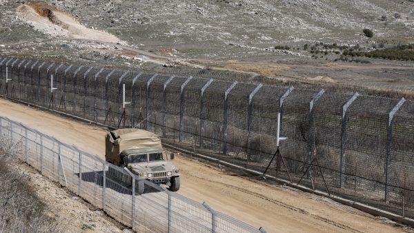 An Israeli army vehicle moves along a road by the barbed-wire fence of the UN-patrolled buffer zone separating Israeli and Syrian forces in the Golan Heights near the Druze village of Majdal Shams on March 2, 2025. (Photo by Jalaa MAREY / AFP) Israeli army chief highlights strategic military presence amid Syrian disintegration