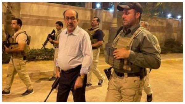 المالكي حاملا السلاح في أحد شوارع بغداد