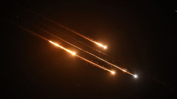 Debris of missiles fired from Iran toward Israel leave trails in the night sky over Nablus in the occupied West bank after being intercepted on June 13, 2025