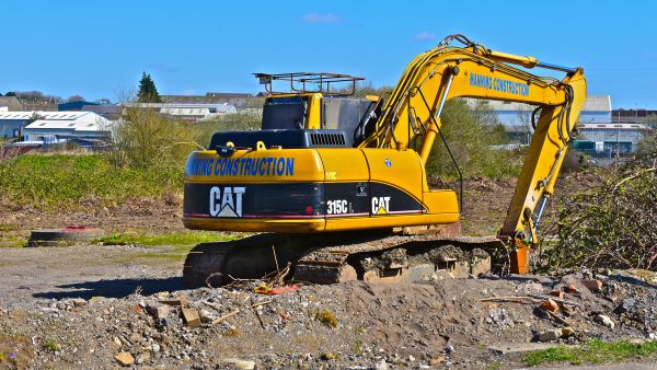 Bridgend. County Borough of Bridgend / Wales UK - 3/24/2019: New building site on the outskirts of Bridgend. A Caterpillar 315CL hydraulic excavator.
