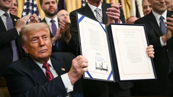 US President Donald Trump displays the GENIUS Act 