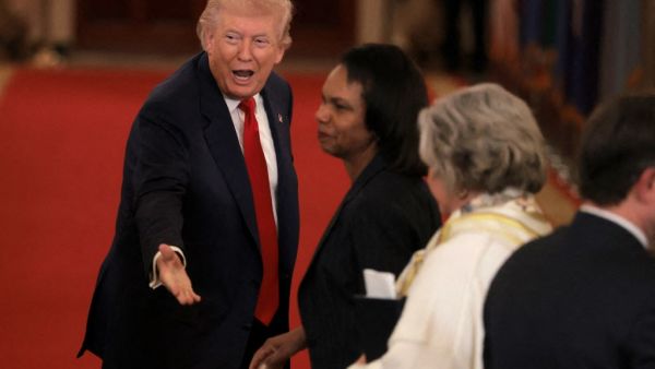  U.S. President Donald Trump speaks to former U.S. Secretary of State Condoleezza Rice
