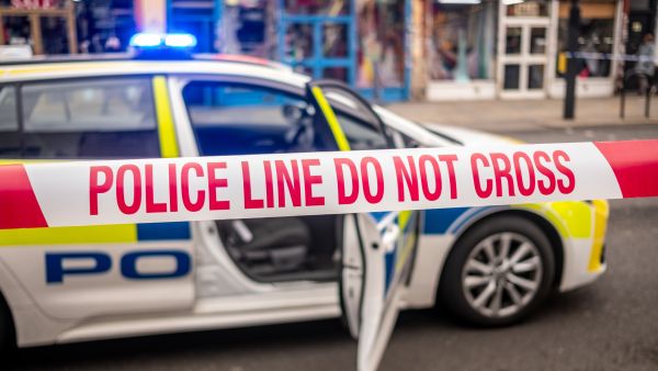 شريط الشرطة وسيارة شرطة في موقع جريمة خطيرة في لندن - المملكة المتحدة