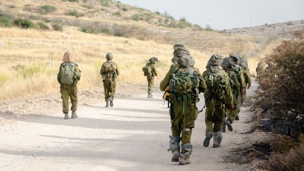 جنود إسرائيليون مقاتلون من فرقة مكافحة الإرهاب يعودون على طريق حصوي مع بزوغ أول ضوء النهار بعد عملية ليلية ناجحة في جنوب لبنان.