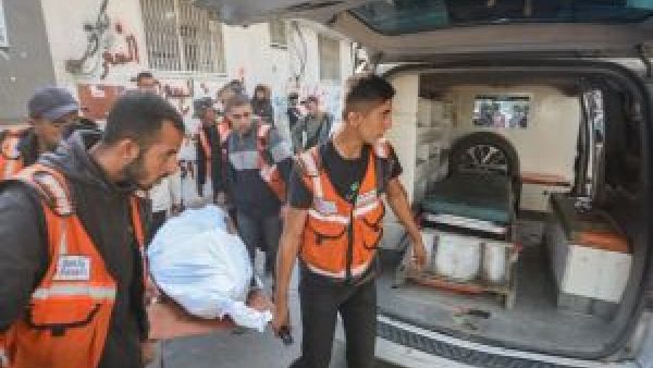  مسعفون وعاملو إغاثة ينقلون مصابًا أو جثمانًا إلى سيارة إسعاف أمام أحد المرافق الطبية في قطاع غزة