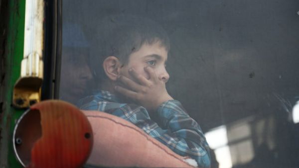 A child looks out of the window as buses carrying Jaish al-Islam fighters and their families from their former rebel bastion of Douma, arrive at the Abu al-Zindeen checkpoint controlled by Turkish-backed rebel fighters near the northern Syrian town of al-Bab, on Apr. 12, 2018. Rebels in Syria's Eastern Ghouta surrendered their heavy weapons and their leader left the enclave, a monitor said, signalling the end of one of the bloodiest assaults of Syria's seven-year war. (Nazeer al-Khatib / AFP)