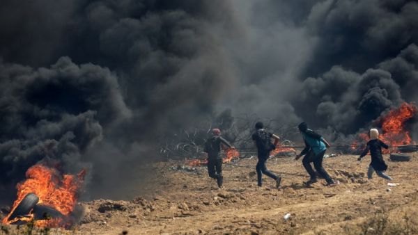 Palestinian protesters pull a metal cable as they try to take down a section of barbed wire at the border fence with Israel, east of Gaza City in the central Gaza Strip, on Apr. 13, 2018. Clashes erupted as thousands protested for a third consecutive Friday along Gaza's border with Israel after violence in which Israeli forces have killed 33 Palestinians and wounded hundreds of others. (MAHMUD HAMS / AFP)