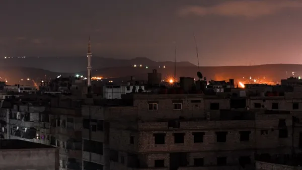 A picture taken early on Apr. 21, 2018 shows explosions appearing in the skyline of a southern district of the Syrian capital Damascus, during regime strikes targeting the Islamic State group in the Palestinian camp of Yarmouk, and neighbouring districts. 
(Rami al SAYED / AFP)