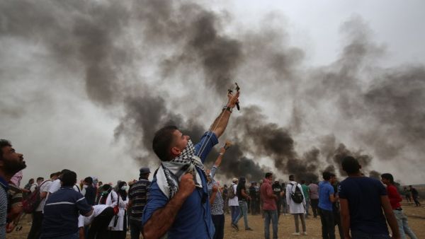 A Palestinian uses a slingshot during a protest demanding the right to return to their historic homeland at the Israel-Gaza border, east of Khan Yunis in the southern Gaza Strip, May 4, 2018. Hundreds of Palestinians gathered on the Gaza border Friday for the sixth week of protests in which dozens have already been killed by Israeli fire. (SAID KHATIB / AFP)