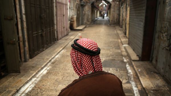 A Palestinian man walks past closed shops on an empty street in the Israeli occupied West Bank city of Nablus on May 15, 2018, during a general strike called for by leaders in solidarity with Gaza and in protest against the US embassy's move to Jerusalem. (Jaafar ASHTIYEH / AFP)