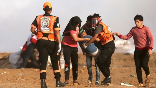 Palestinians carry an injured protester during clashes with Israeli forces along the border with the Gaza strip east of Jabalia on May 18, 2018. (MOHAMMED ABED / AFP)