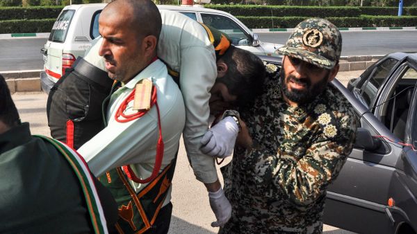This picture taken on September 22, 2018 in the southwestern Iranian city of Ahvaz shows an Iranian soldier carrying an ijured comrade at the scene of an attack on a military parade (AFP)