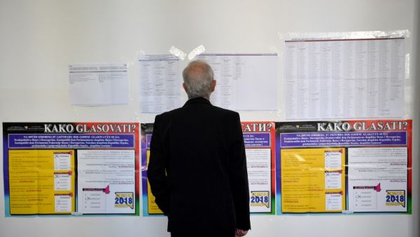 A man looks at a list of candidates at a polling station in Sarajevo on October 7, 2018 as Bosnia and Herzegovina holds it's general elections (AFP)