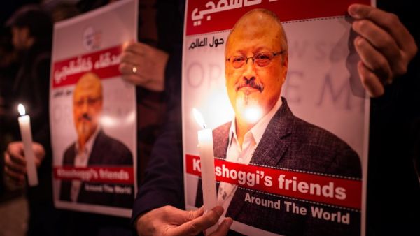 People hold posters picturing Saudi journalist Jamal Khashoggi and lightened candles during a gathering outside the Saudi Arabia consulate in Istanbul, on October 25, 2018. (Yasin AKGUL / AFP)