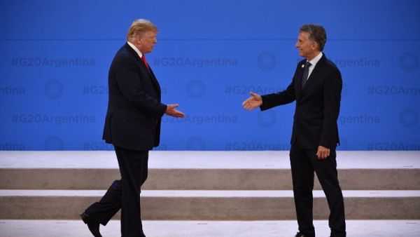 US President Donald Trump (L) is welcomed by Argentina's President Mauricio Macri at Costa Salguero in Buenos Aires during the G20 Leaders' Summit (AFP)