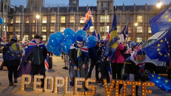 Anti-Brexit demonstrators lay out a sign demanding a second referendum outside Parliament. (Tolga AKMEN / AFP)