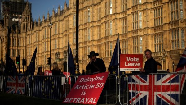 Pro-Brexit activists hold placards as they demonstrate outside of the Houses of Parliament in London On February 26, 2019. (Daniel LEAL-OLIVAS / AFP)