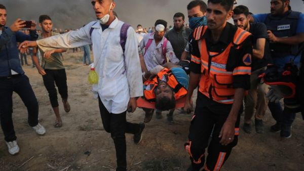 Palestinian paramedics carry a wounded protester during clashes with Israeli forces east of Gaza city, along the Gaza-Israel border in the Gaza Strip. (AFP/File)