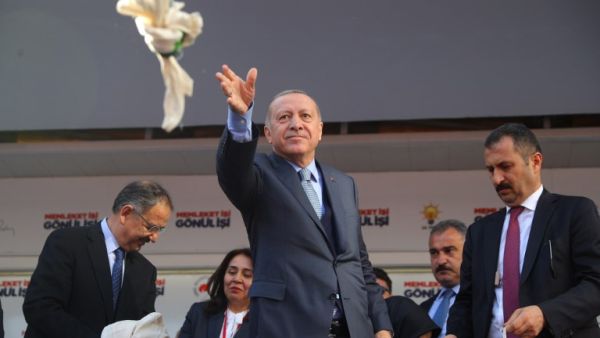 Turkish President and leader of Turkey's ruling Justice and Development (AK) Party Recep Tayyip Erdogan throws bags of tea to his supporters. (Adem ALTAN / AFP)