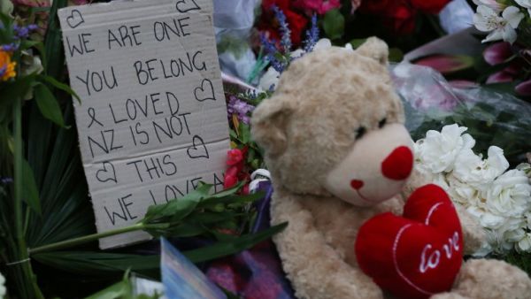 A note is seen beside floral tributes at a makeshift memorial for victims (AFP)