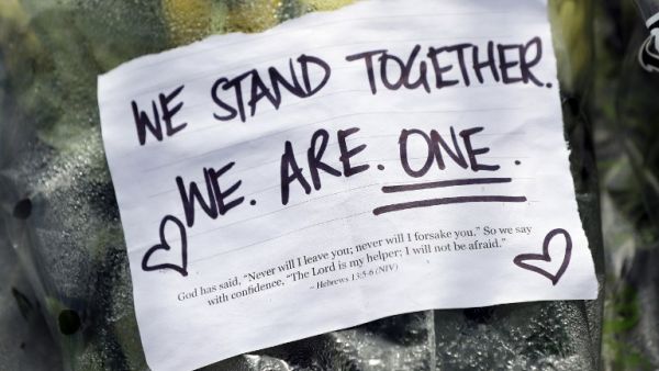 Residents pay their respects by placing flowers for the victims of the mosques attacks in Christchurch at the Masjid Umar mosque in Auckland  (AFP)