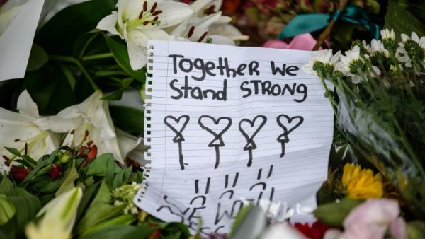 A handwritten note is displayed among flowers during a vigil in Christchurch (AFP)