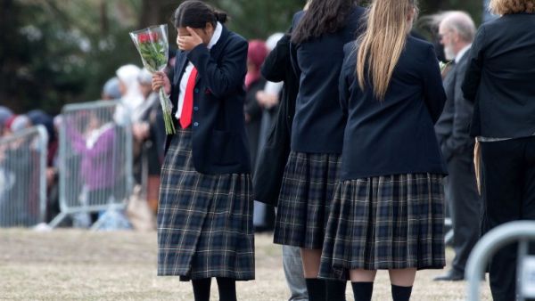 A schoolgirl gestures as mourners proceed during the funeral of Muhammad Haziq Mohd-Tarmizi at Memorial Park Cemetery in Christchurch on March 21, 2019. (AFP)