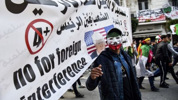 An Algerian wearing a Guy Fawkes' mask defaced with the national colours marches during a demonstration against ailing President Abdelaziz Bouteflika in the capital Algiers on March 22, 2019. (AFP/ File)