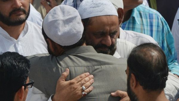Mourners comfort the father (centre R) of Syed Areeb Ahmed, a Pakistani victim of the Al Noor Mosque attack in New Zealand, during his funeral in Karachi (AFP)