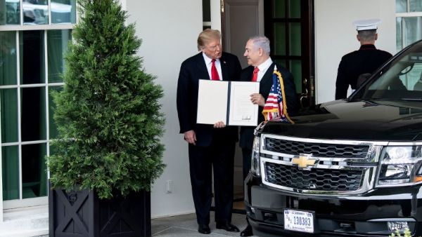 US President Donald Trump (L) and Israel's Prime Minister Benjamin Netanyahu hold up a Golan Heights proclamation outside the West Wing after a meeting in the the White House  (AFP)
