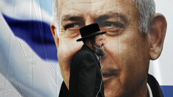An Ultra Orthodox Jewish man walks past an electoral billboard bearing a portrait of Israel's Prime Minister Benjamin Netanyahu, in Jerusalem, on April 1, 2019. Israeli general elections will be held on April 9, 2019.
THOMAS COEX / AFP 