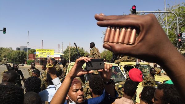 A Sudanese protester shows bullet cartridges as others gather in front of security forces during a demonstration in the area of the military headquarters in the capital Khartoum on April 8, 2019. (AFP)