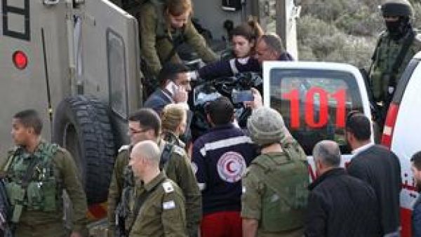 Israeli security forces stand next to a stretcher carrying the body of Haitham al-Bau as they hand over the body to members of the Palestinian Red Crescent on February 5, 2016. (AFP/Hazem Bader)