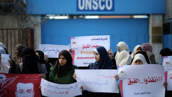 Palestinian women hold posters bearing a portrait of Palestinian hunger striking Palestinian journalist Mohammed al-Qiq on February 21, 2016. (AFP/Mahmud Hams)
