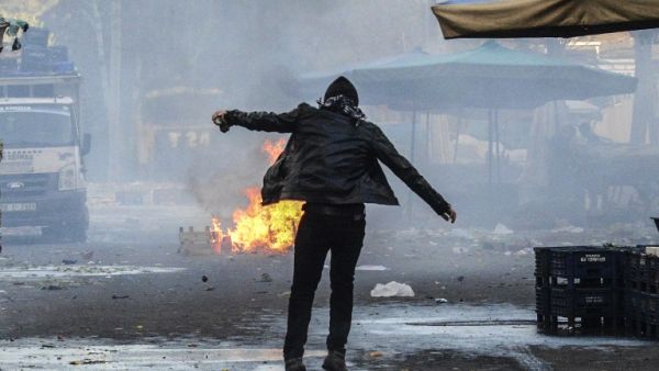 A protester stands close to a fire, during clashes between Turkish forces and Kurdish people in the center of Diyarbakir, during a protest against a curfew in the Sur district of Diyarbakir, on March 2, 2016. (AFP/Ilyas Askengin)
