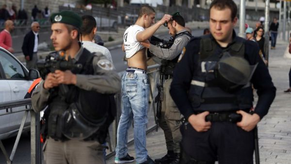 Israeli security forces body-check a Palestinian young man at the entrance of Damascus Gate, outside Jerusalem's Old City, on March 9, 2016. (AFP/Ahmad Gharabli)